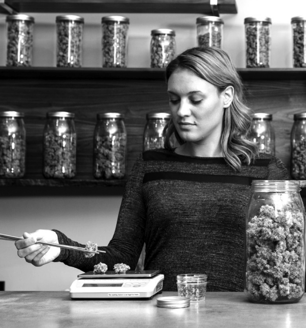 Lady measuring cannabis on a scale in a retail setting