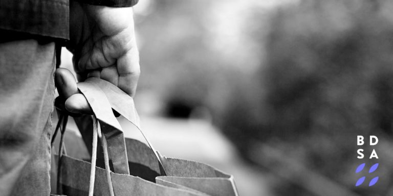 Man holding bags BW 2X1 Moved Logo